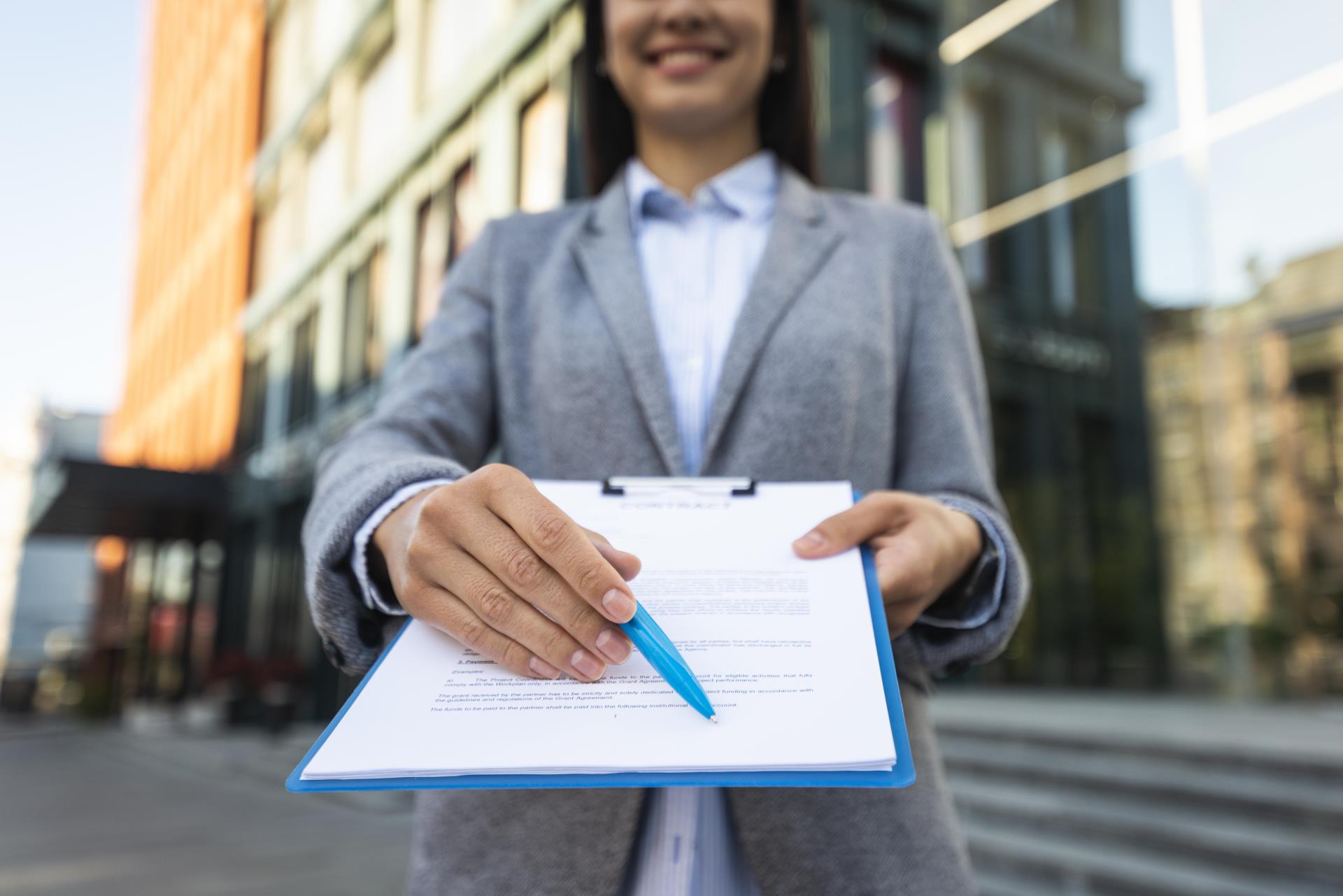 smiley-businesswoman-showing-you-where-sign-clipboard