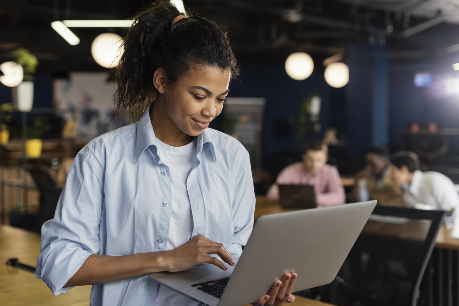 smiley-woman-holding-laptop-office-working