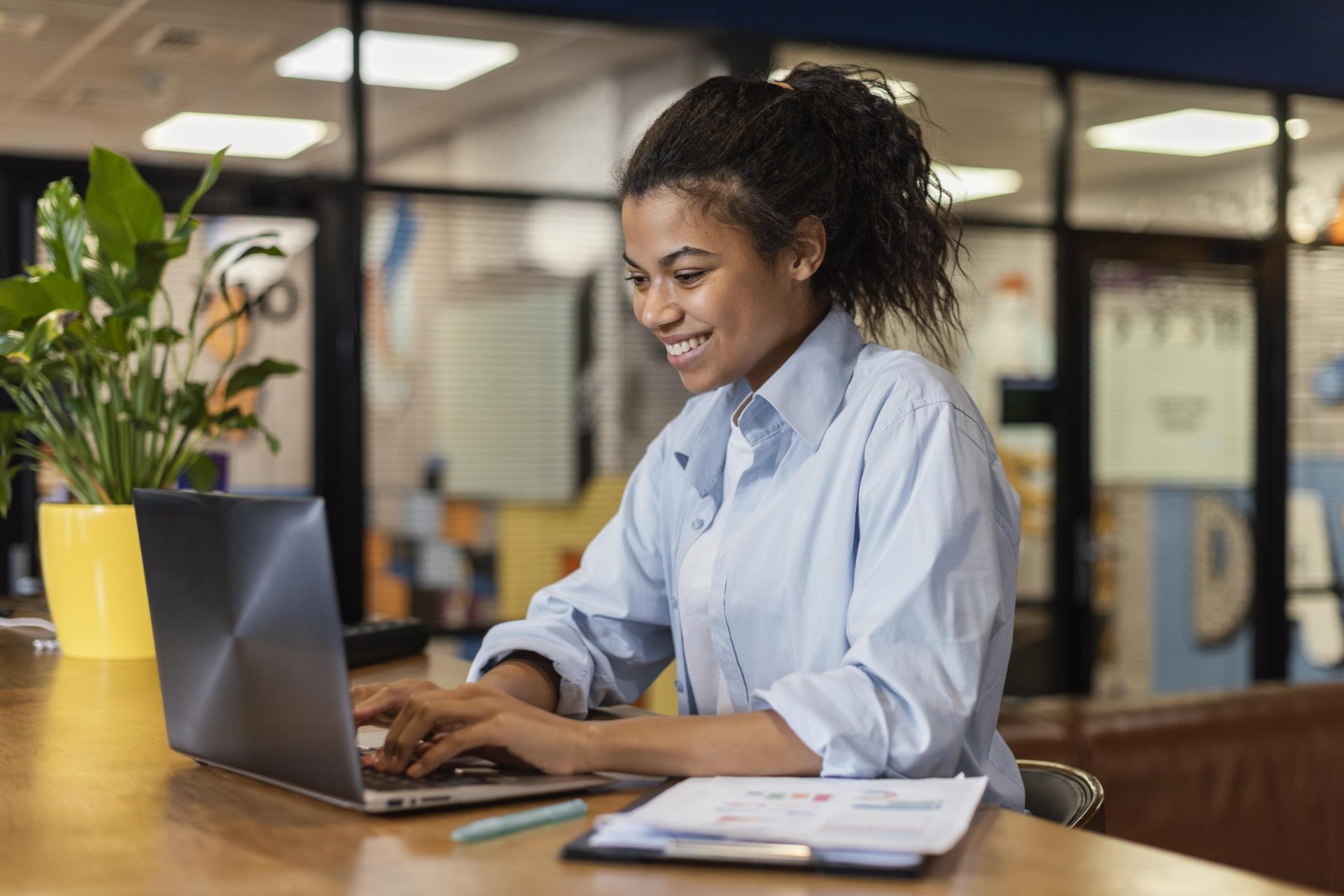 side-view-smiley-woman-working-with-laptop-office