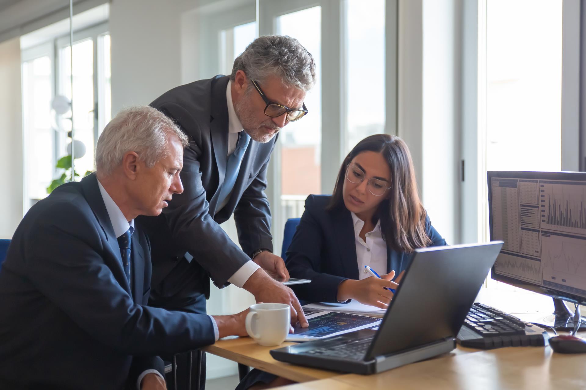 concentrated-colleagues-watching-statistic-charts-talking-about-work-professional-senior-managers-young-assistant-preparing-business-plan-teamwork-management-partnership-concept