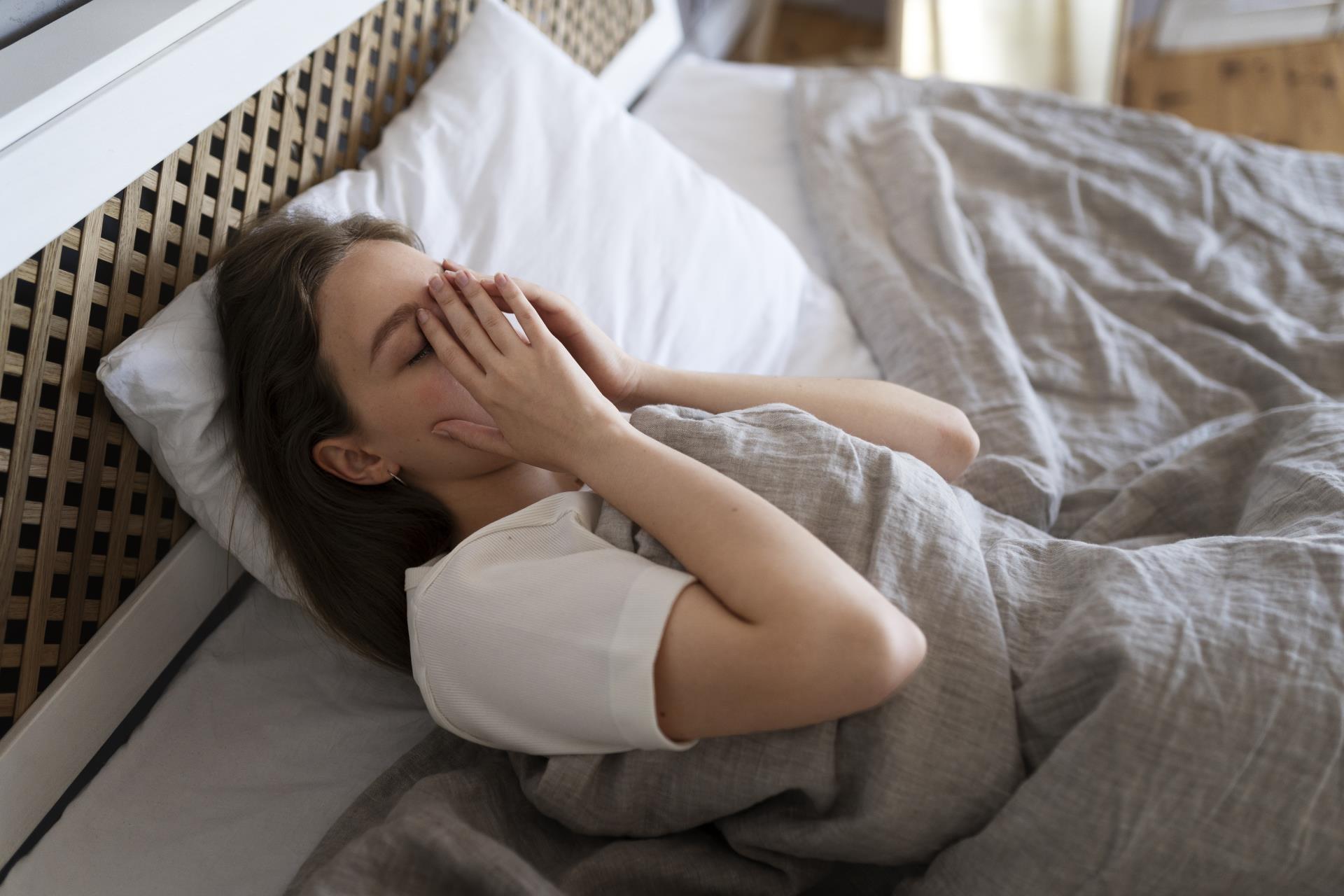 high-angle-anxious-woman-laying-bed