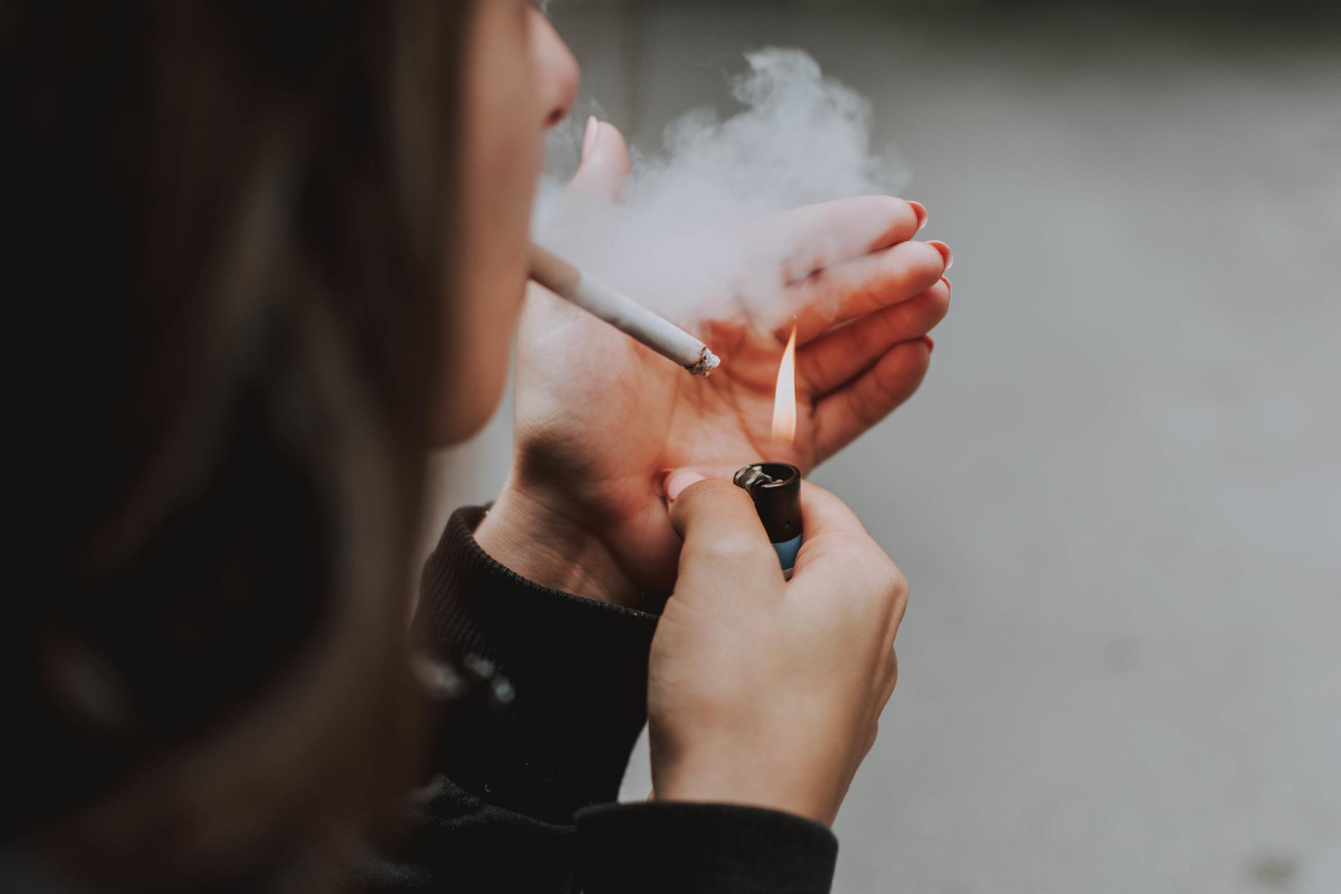 selective-closeup-shot-female-lighting-up-cigarette-with-lighter