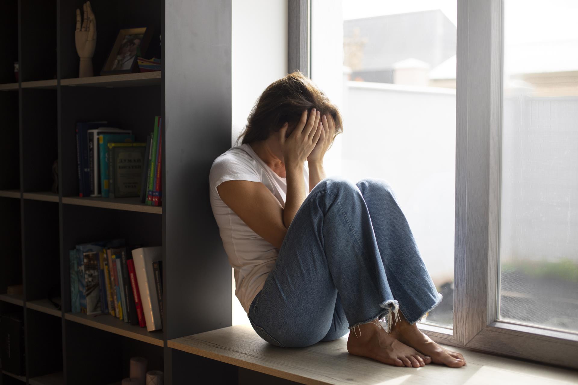 portrait-young-woman-with-low-self-esteem-sitting-by-window-home