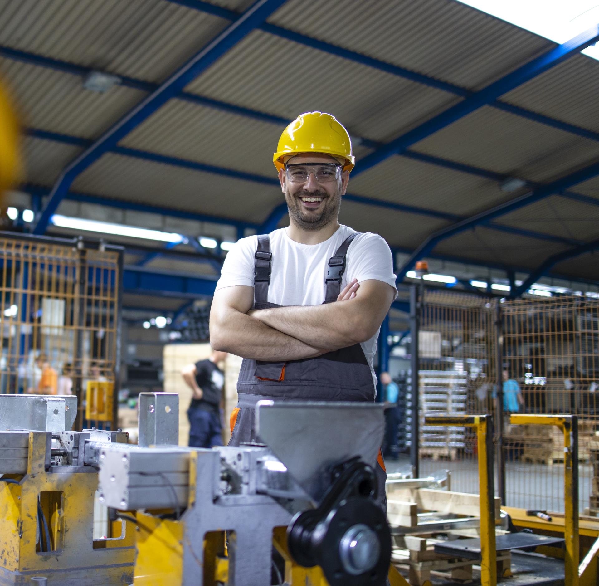 portrait-factory-worker-with-arms-crossed-standing-by-industrial-machine