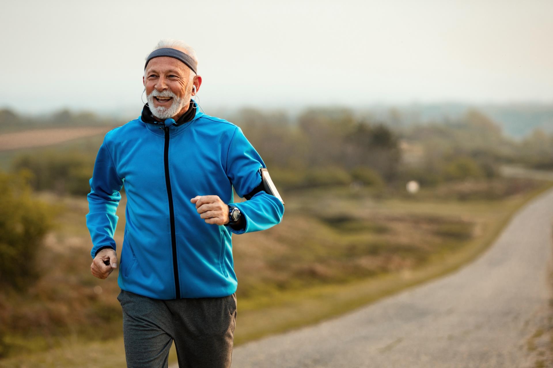 happy-senior-sportsman-feeling-motivated-while-listening-music-running-nature-copy-space