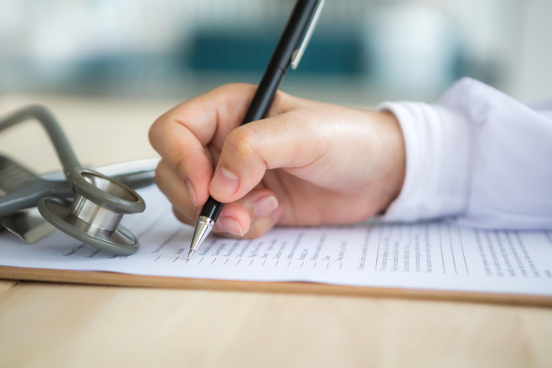 hand-with-pen-filling-out-document