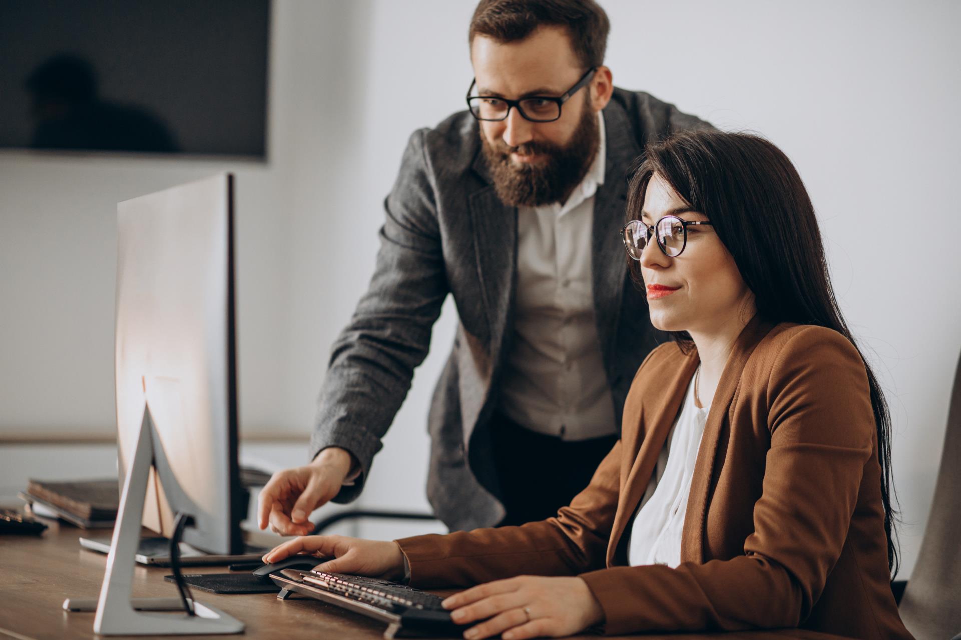 two-business-partners-working-together-office-computer