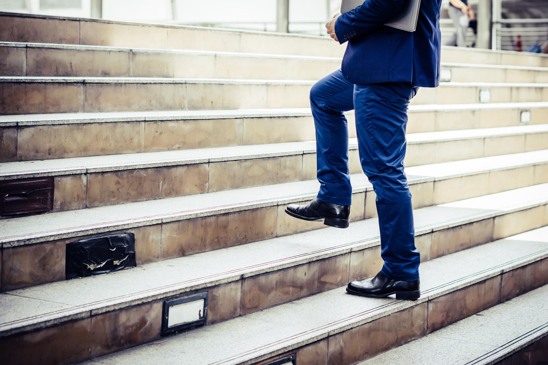 close-up-young-businessman-walking-upstairs-outside-office