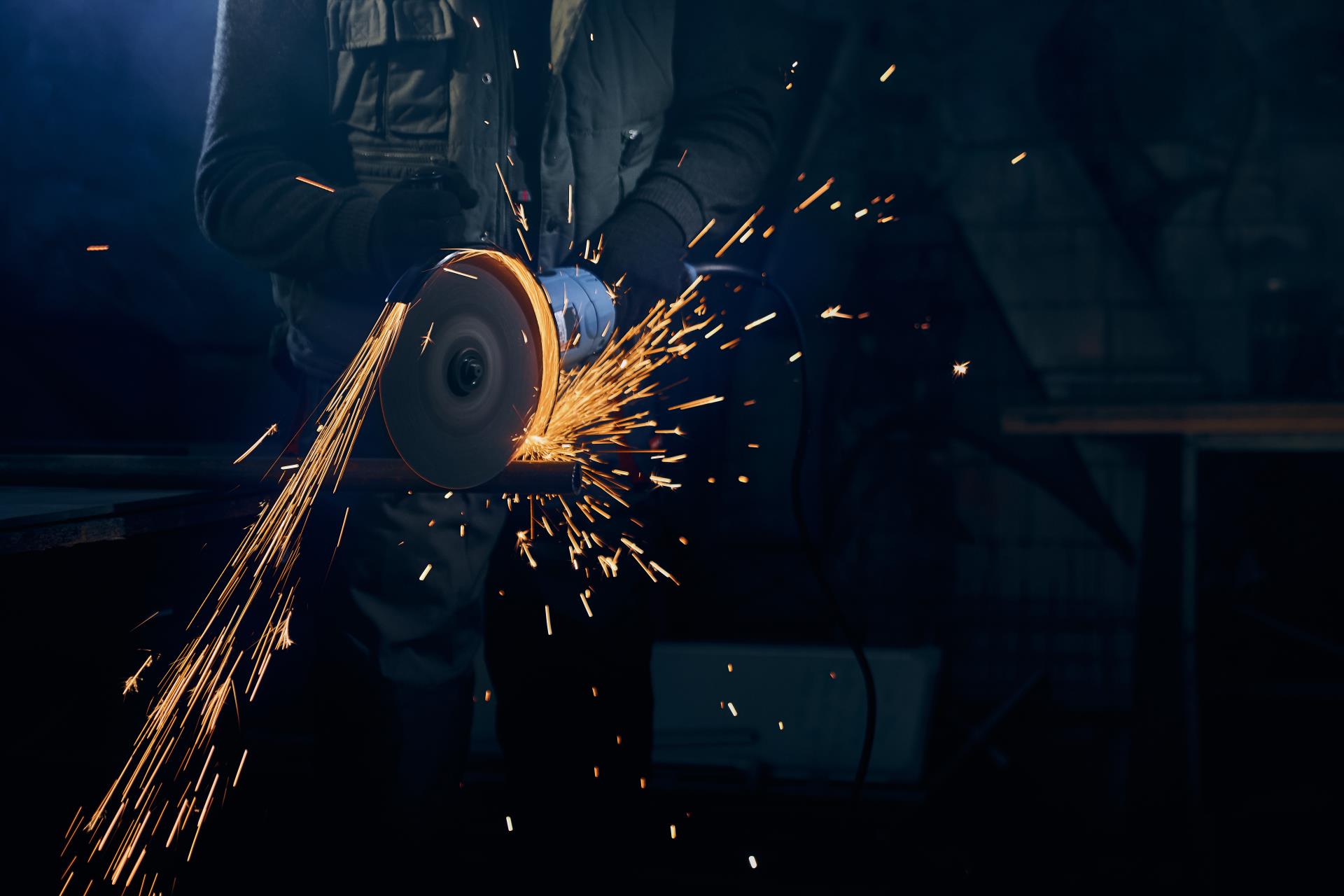 young-man-cutting-with-rotating-disc-metal-with-sparks