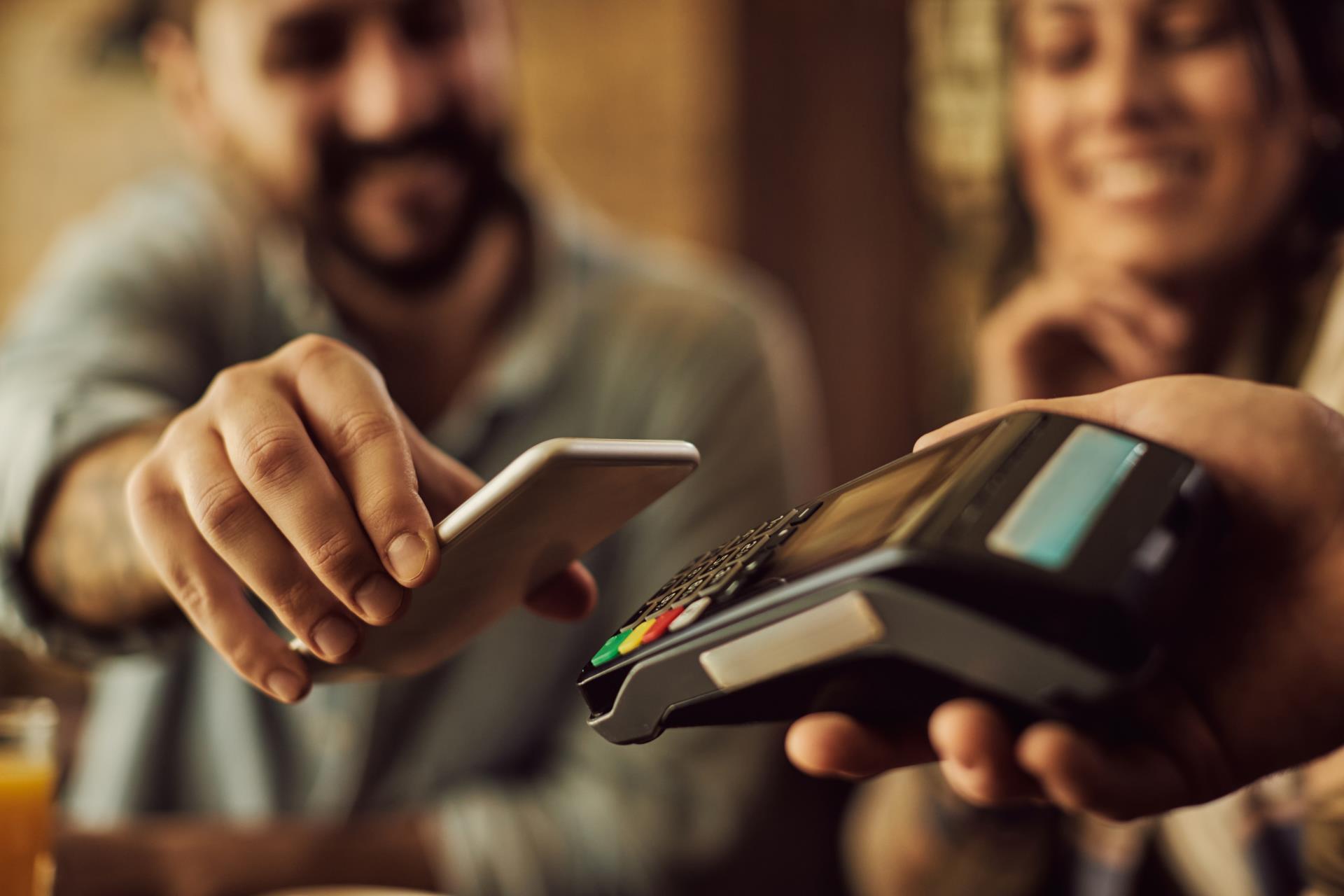 closeup-man-making-contactless-payment-with-smart-phone