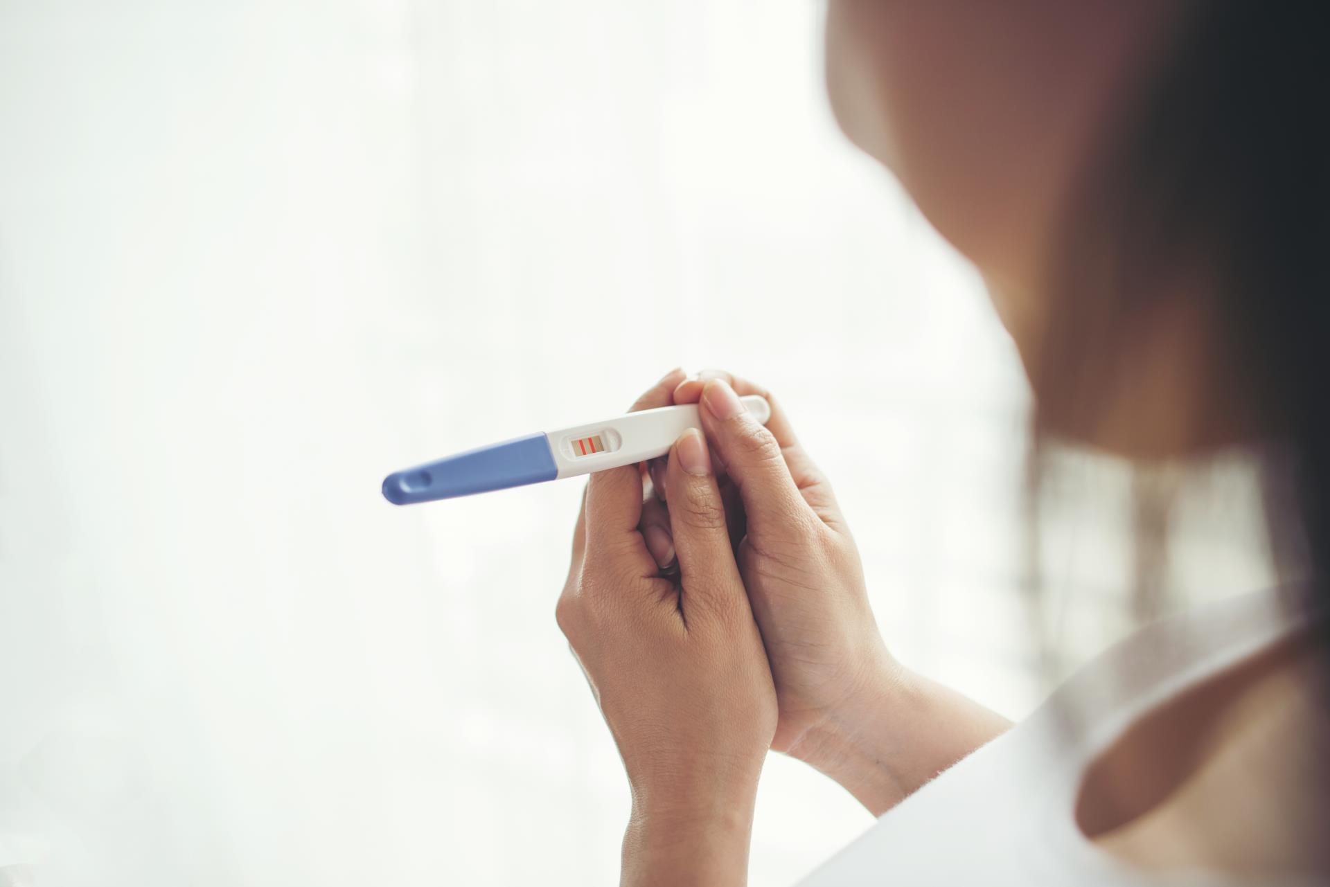 young-woman-hand-holding-pregnancy-test