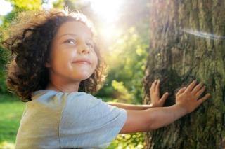 side-view-smiley-kid-near-tree