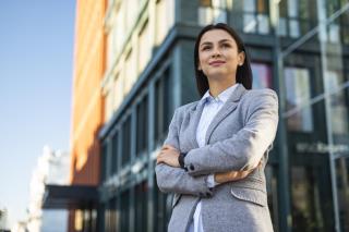 low-angle-businesswoman-posing-with-arms-crossed-outdoors