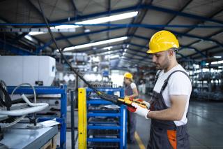 factory-worker-wearing-uniform-hardhat-operating-industrial-machine-with-push-button-joystick-production-hall