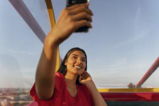 person-taking-selfie-with-smartphone-while-ferris-wheel