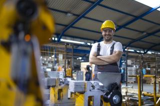 portrait-factory-worker-with-arms-crossed-standing-by-industrial-machine