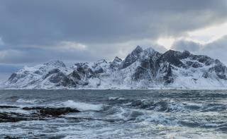 beautiful-shot-sea-waves-with-snowy-mountain-background