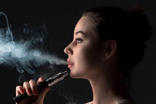 face-vaping-young-woman-black-studio