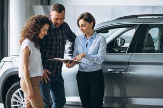 young-couple-talking-sales-person-car-showroom