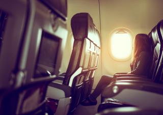 lady-is-sitting-airplane-looking-out-shiny-sun-through-window