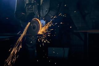 young-man-cutting-with-rotating-disc-metal-with-sparks