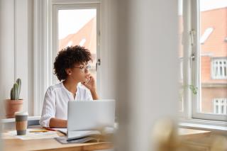 photo-female-entrepreneur-speaks-via-cell-phone-looks-thoughtfully-into-window-analyzes-paperwork-from-accounting-department