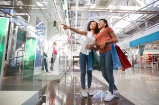 two-excited-black-girls-pointing-shop-window