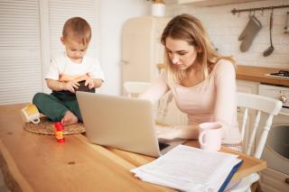 worried-upset-young-blonde-female-sitting-kitchen-table-with-papers-portable-computer-feeling-stressed-because-she-has-make-report-take-care-her-baby-son-while-he-is-staying-home